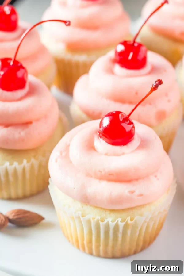 Cherry Almond Cupcakes. Fluffy, moist, super soft almond cupcakes topped with maraschino cherry frosting. www.justsotasty.com