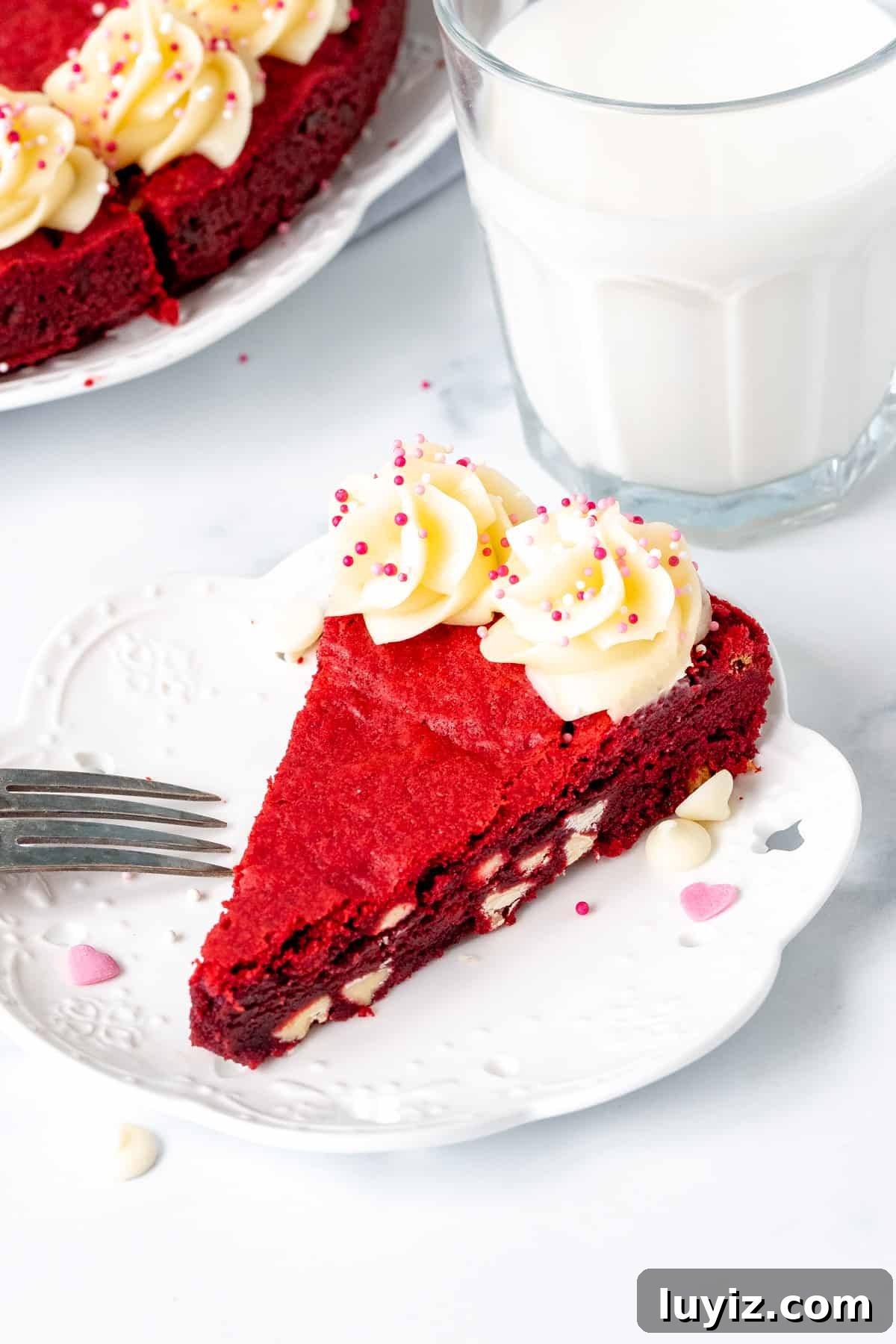Red Velvet Cookie Cake Recipe: Decadent Layered Dessert Guide 4 Slice of white chocolate chip red velvet cookie cake with glass of milk