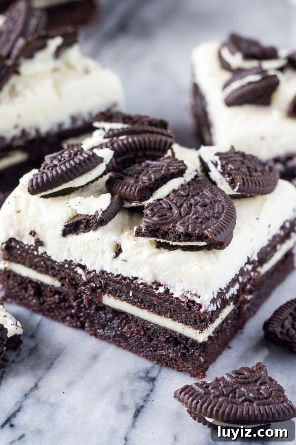 Marshmallow Oreo Brownies. Fudgy brownies stuffed with Oreo cookies, and topped with fluffy marshmallow frosting and more Oreo cookies. www.justsotasty.com