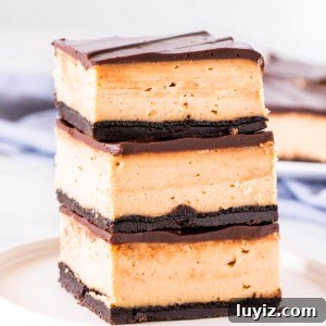 Peanut Butter Cheesecake Bars Recipe — Creamy No-Bake Dessert 7 Stack of 3 peanut butter cheesecake bars with Oreo crust and chocolate topping.