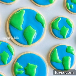 Earth Day Cookie Recipes to Celebrate Sustainability 7 Cut out sugar cookies decorated as earth on white background.