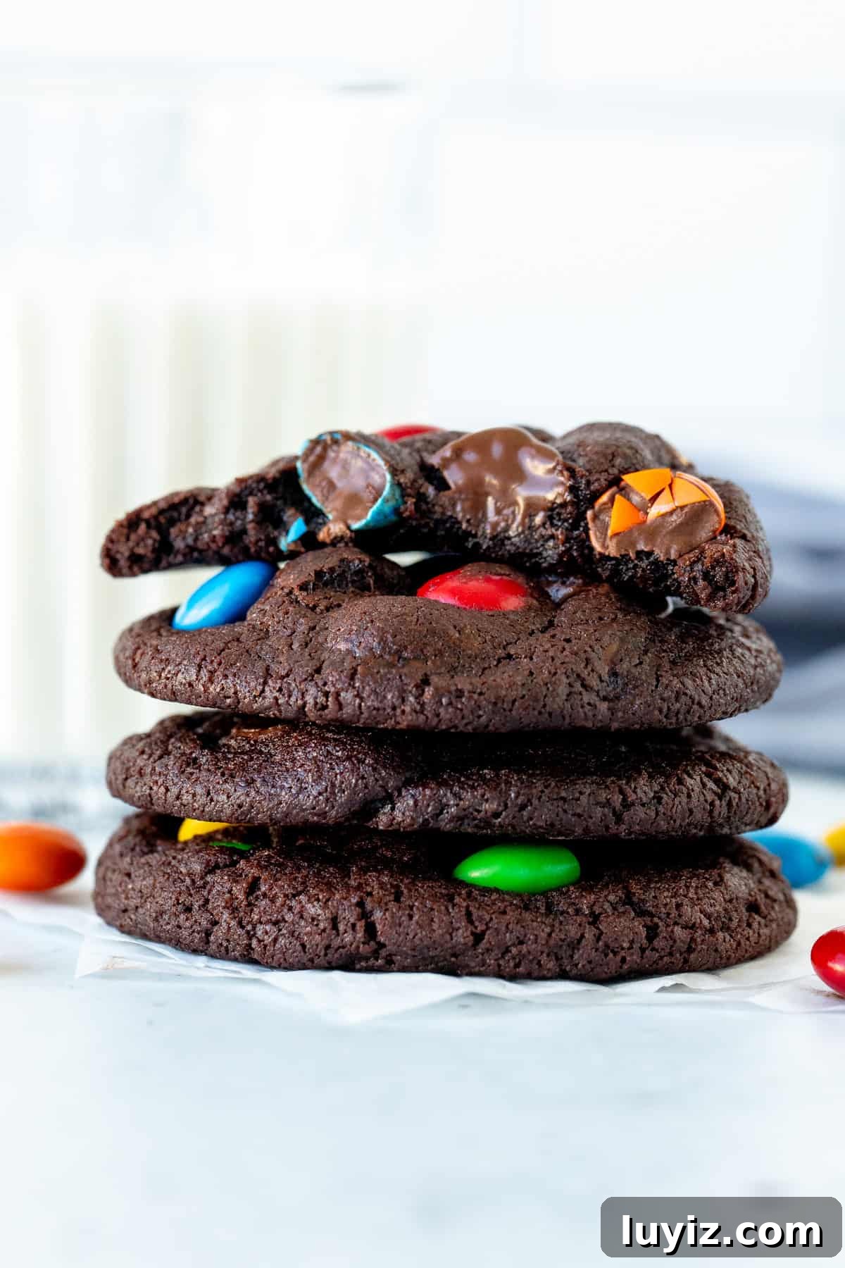 Crispy M&M Chocolate Cookie Recipe for Perfect Party Treats 2 Stack of chocolate M&M cookies with top cookie broken in half