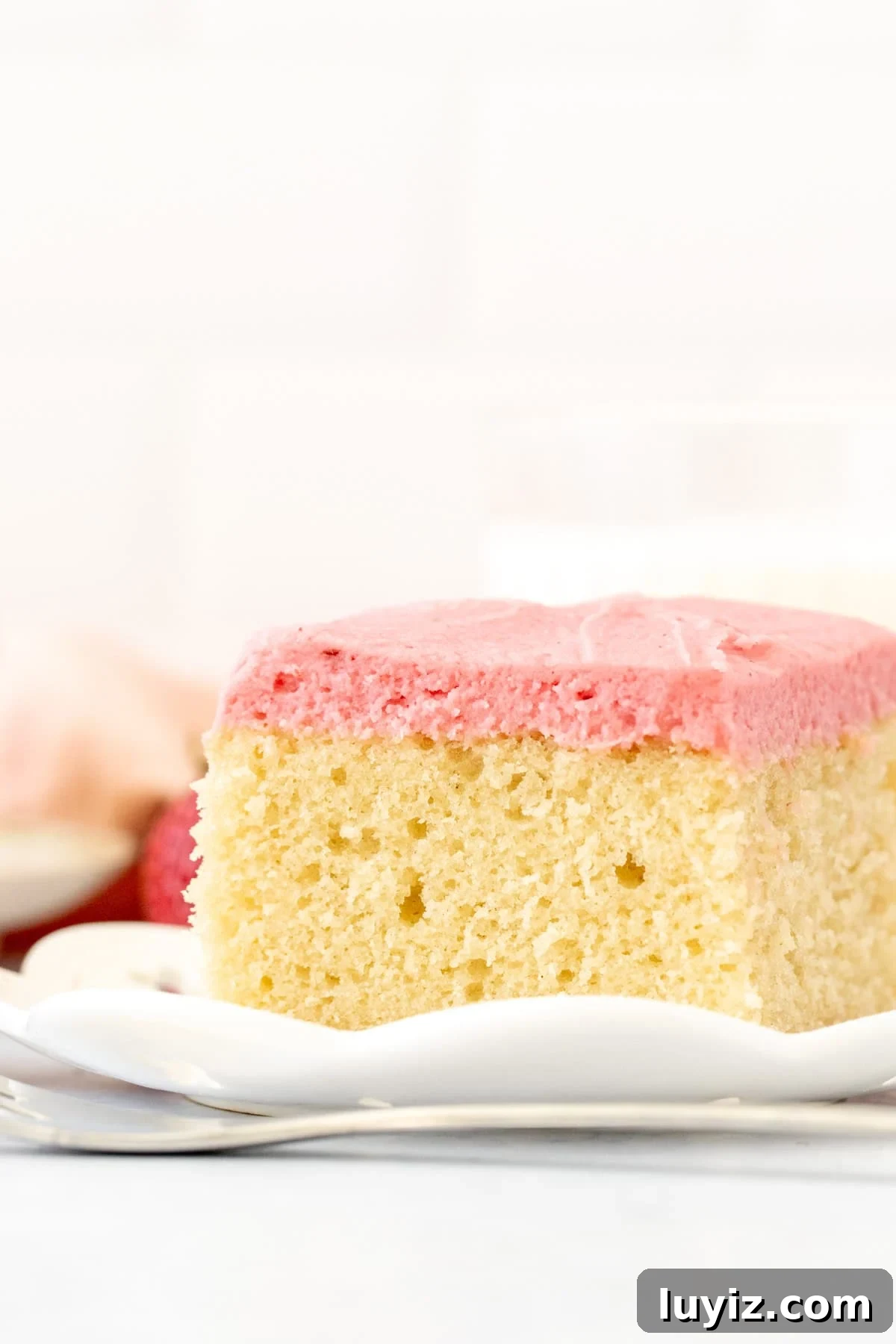 Vanilla Layer Cake with Strawberry Buttercream Frosting 3 Square piece of vanilla cake topped with strawberry frosting