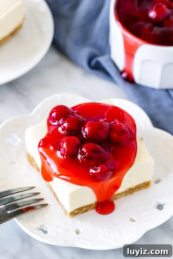 No-Bake Cherry Cheesecake Bars Recipe for Summer Treats 5 Slice of cheesecake square with cherry topping