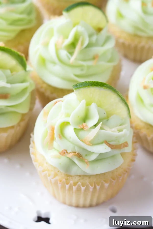 Coconut Cupcakes with Zesty Lime Buttercream Frosting 4 Overhead view of a plate of coconut cupcakes with lime buttercream frosting.