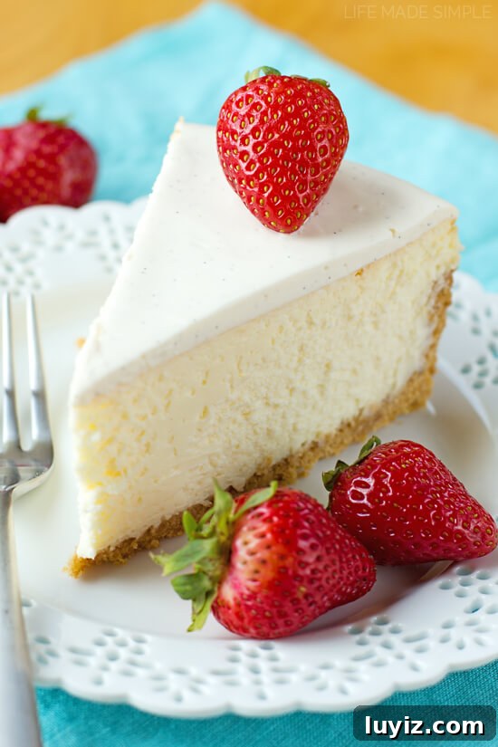 How to Make Cheesecake: Complete Guide for Perfect Results 5 Slice of New York cheesecake on white plate topped with a strawberry.