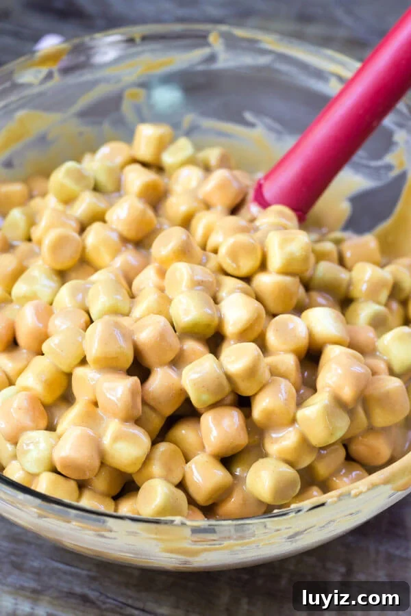 Confetti Peanut Butter Marshmallow Squares Recipe 3 Confetti square batter in a bowl with red spatula.