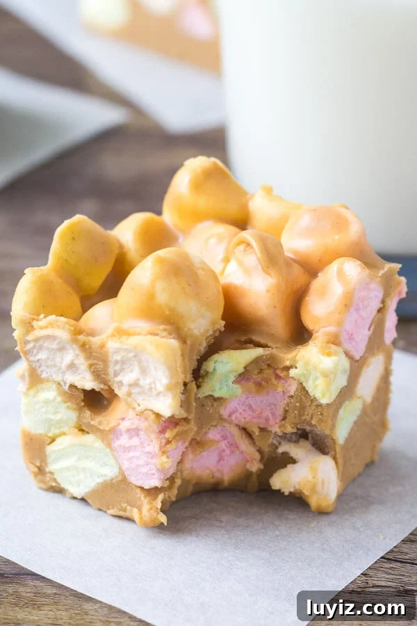 Confetti Peanut Butter Marshmallow Squares Recipe 5 Confetti square with a bite taken out of it and a glass of milk.