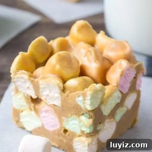 Confetti Peanut Butter Marshmallow Squares Recipe 6 Confetti square made with rainbow marshmallows, butterscotch chips & peanut butter with a glass of milk and 2 squares in the background