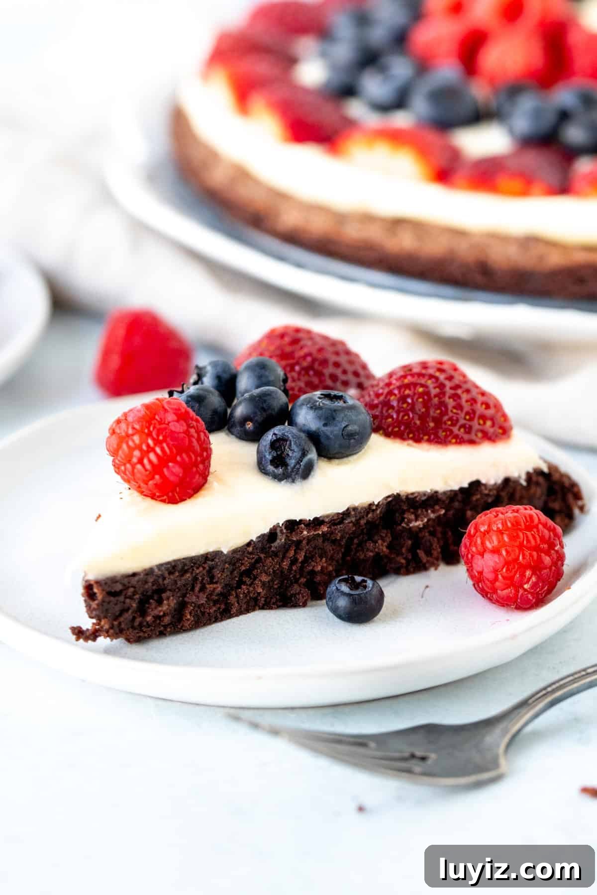 Decadent Brownie Fruit Pizza Recipe with Fresh Berries 3 Triangle of brownie topped with cream cheese frosting and fresh berries