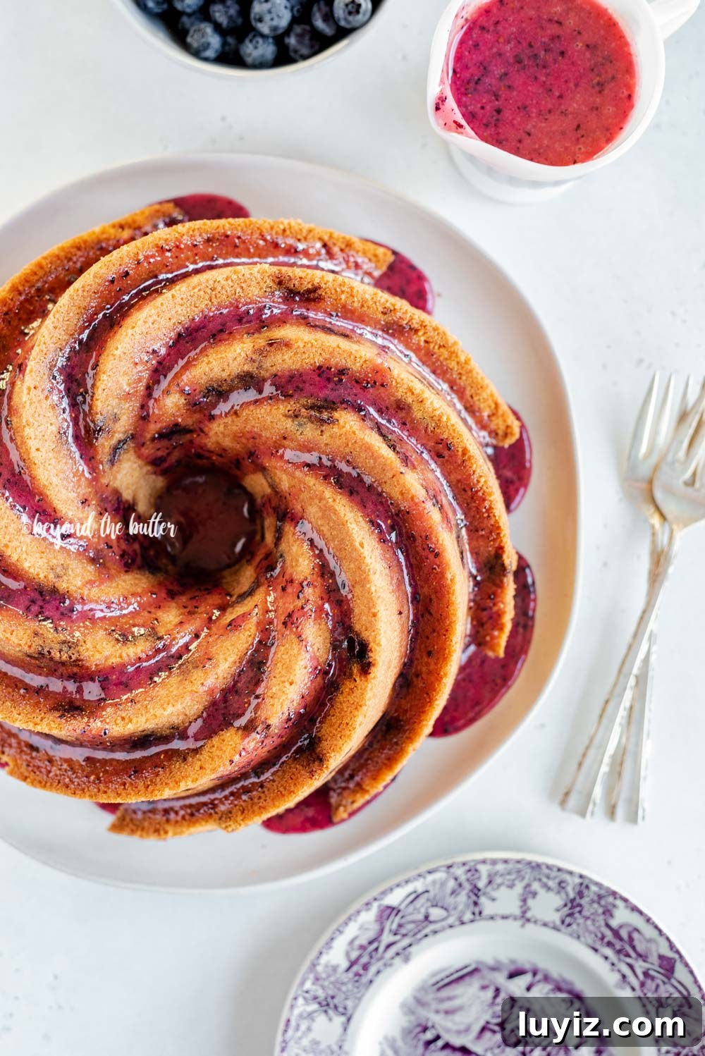 Moist Blueberry Bundt Cake with Lemon Glaze 14 Overhead image of super easy blueberry bundt cake recipe with blueberry glaze drizzled over the top | All Images © Beyond the Butter, LLC