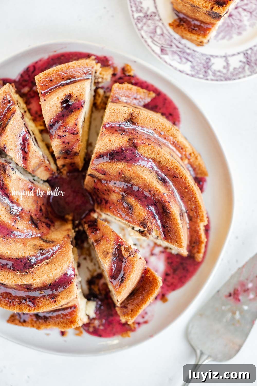 Moist Blueberry Bundt Cake with Lemon Glaze 6 Overhead image of sliced blueberry bundt cake with blueberry glaze drizzled over the top | All Images © Beyond the Butter, LLC