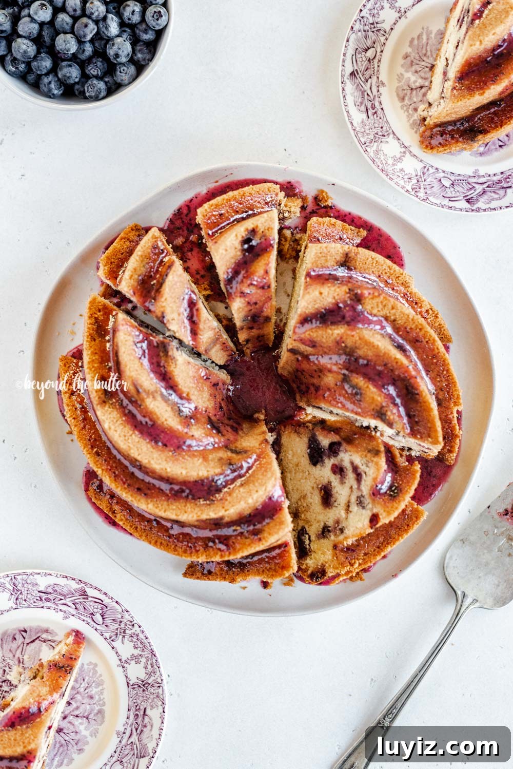 Moist Blueberry Bundt Cake with Lemon Glaze 7 Overhead image of sliced blueberry bundt cake with blueberry glaze drizzled over the top | All Images © Beyond the Butter, LLC