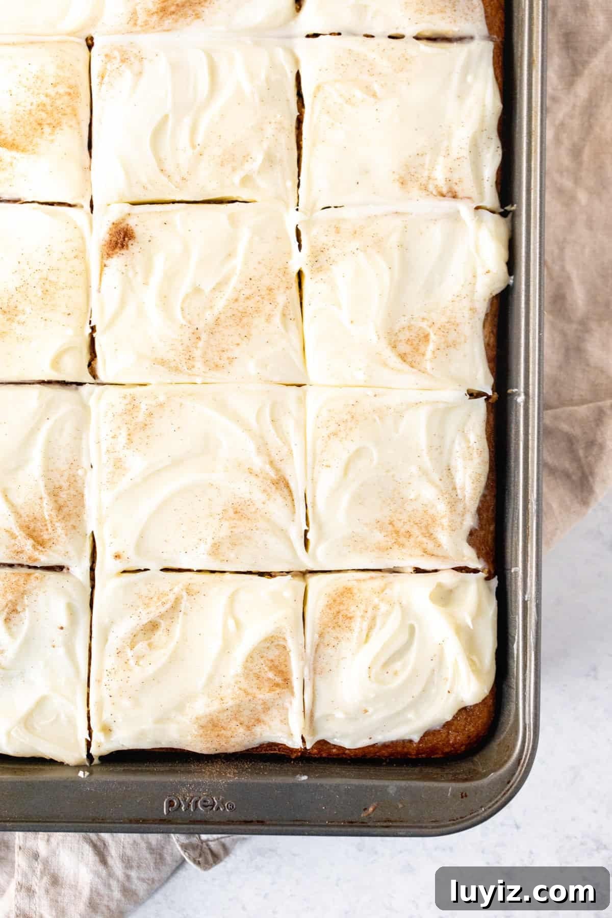 Apple Spice Cake with Cream Cheese Frosting Recipe 10 Pan of apple spice cake with cream cheese frosting, sliced into pieces.
