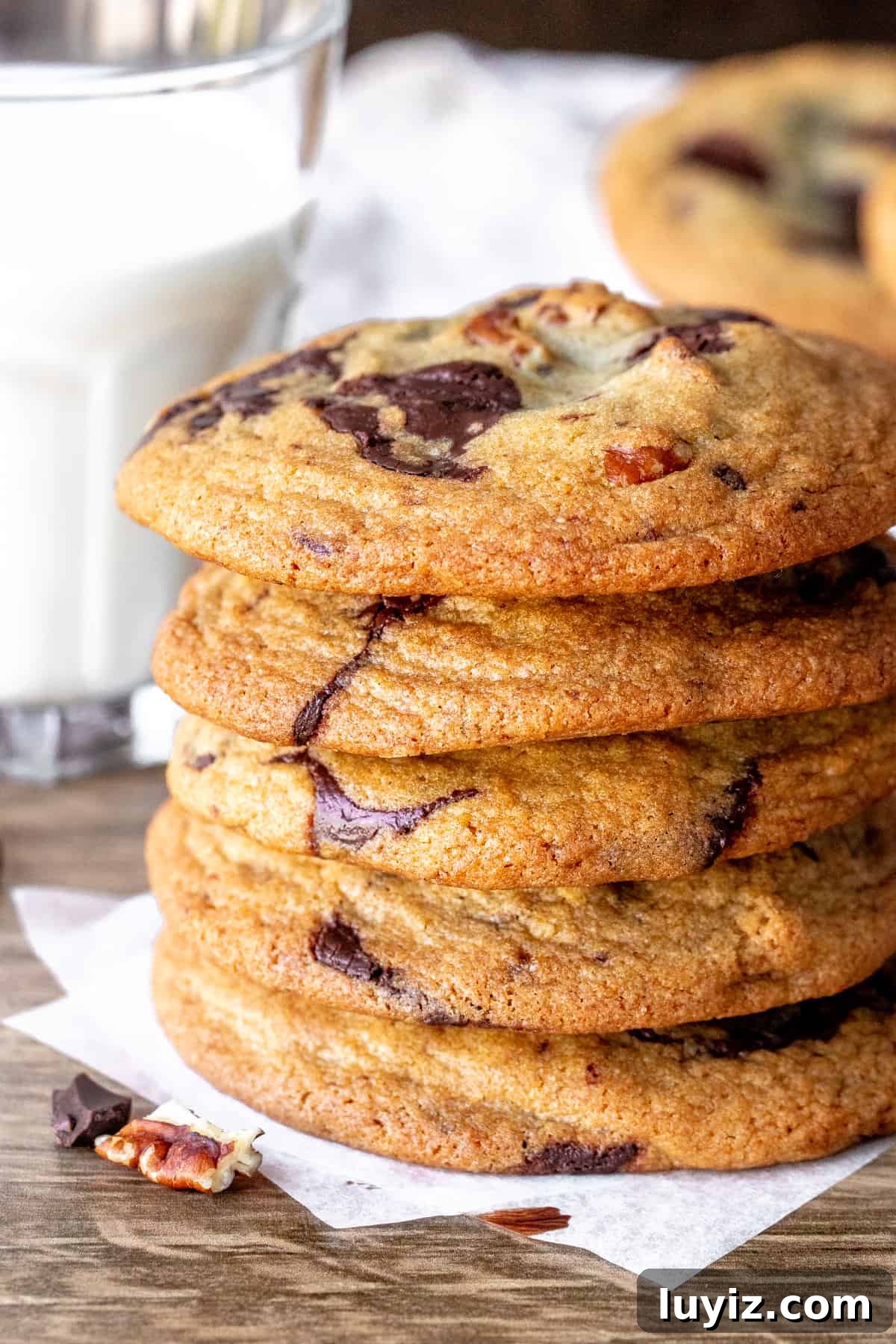 Brown Butter Pecan Chocolate Chip Cookies Recipe 3 Pecan chocolate chip cookies stacked one on top of each other with a glass of milk