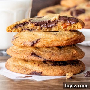 Brown Butter Pecan Chocolate Chip Cookies Recipe 5 Stack of brown butter pecan chocolate chunk cookies with top cookie broken in half.