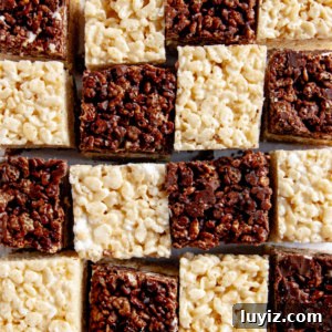 Chocolate and Vanilla Layered Rice Krispie Treats 4 Chocolate-Vanilla Layered Rice Krispie Treats arranged like a checkered board pattern on white parchment paper.