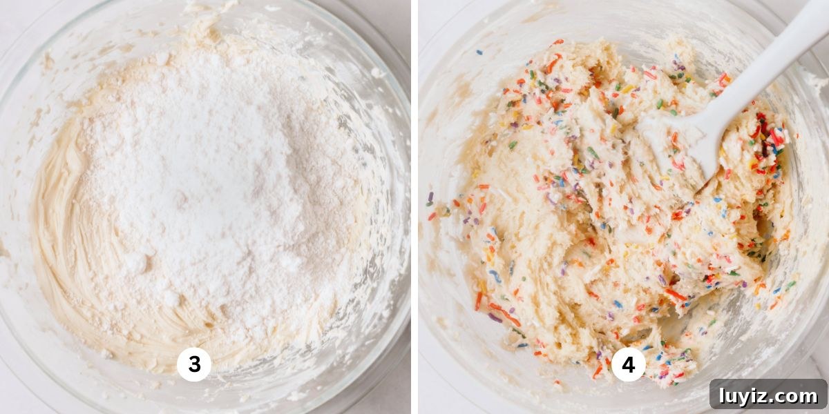 Funfetti Butter Cookies Recipe with Sprinkle-Filled Shortbread 6 Adding white cake mix and sprinkles to funfetti cookie dough using a white spatula in a large glass mixing bowl on a white background.