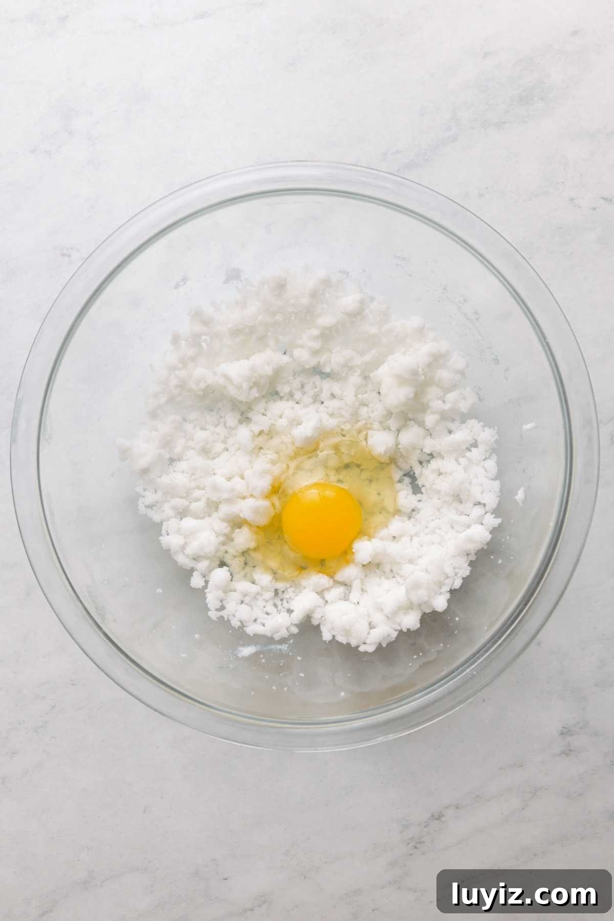 Mini French Breakfast Puffs: Airy, Jam-Filled Pastry Bites 8 Vegetable shortening and granulated sugar beaten together in a large glass mixing bowl with an egg cracked on top.