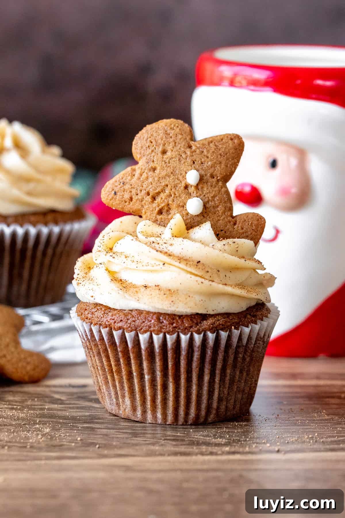Gingerbread Cupcakes with Silky Cream Cheese Frosting 2 Gingerbread cupcake with cream cheese frosting and mini gingerbread man cookie on top.
