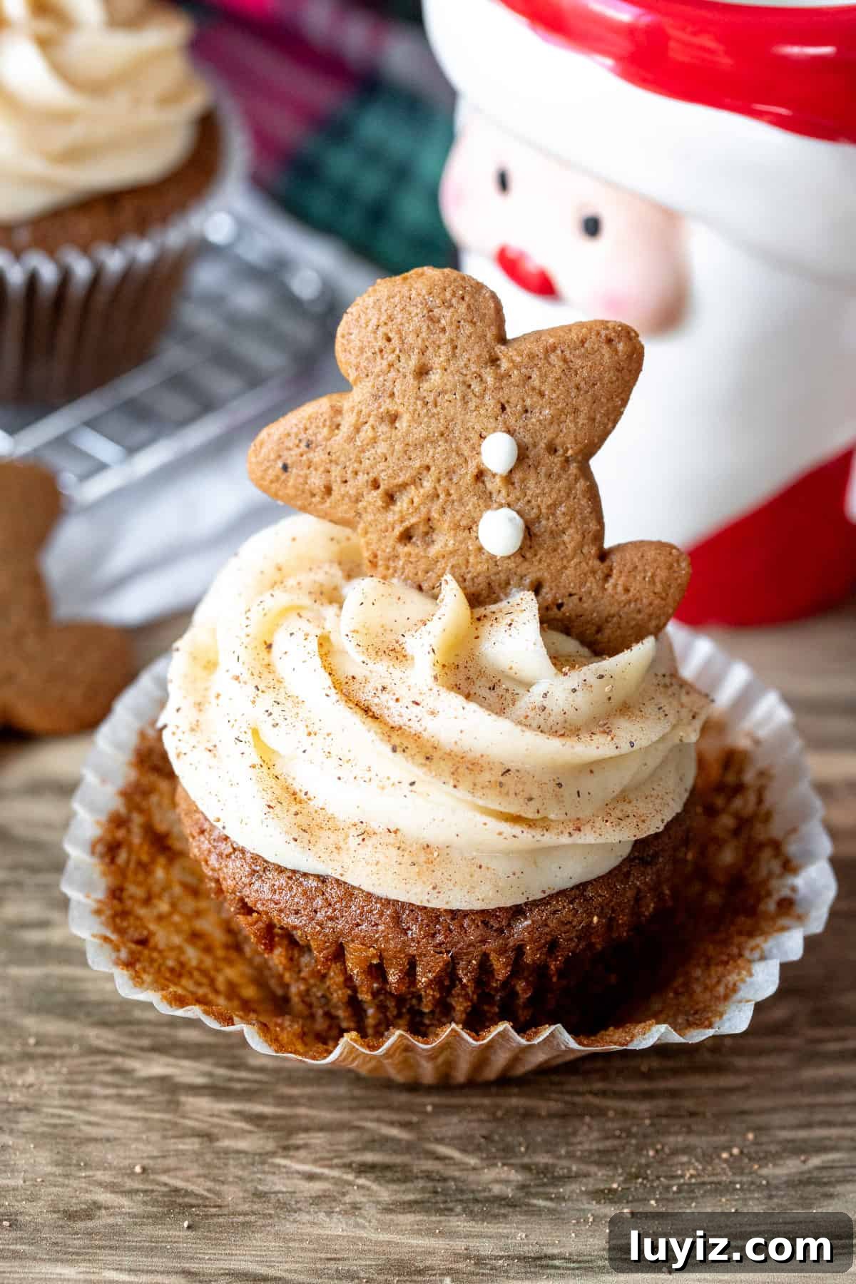 Gingerbread Cupcakes with Silky Cream Cheese Frosting 6 Christmas cupcake topped with gingerbread man with paper removed.