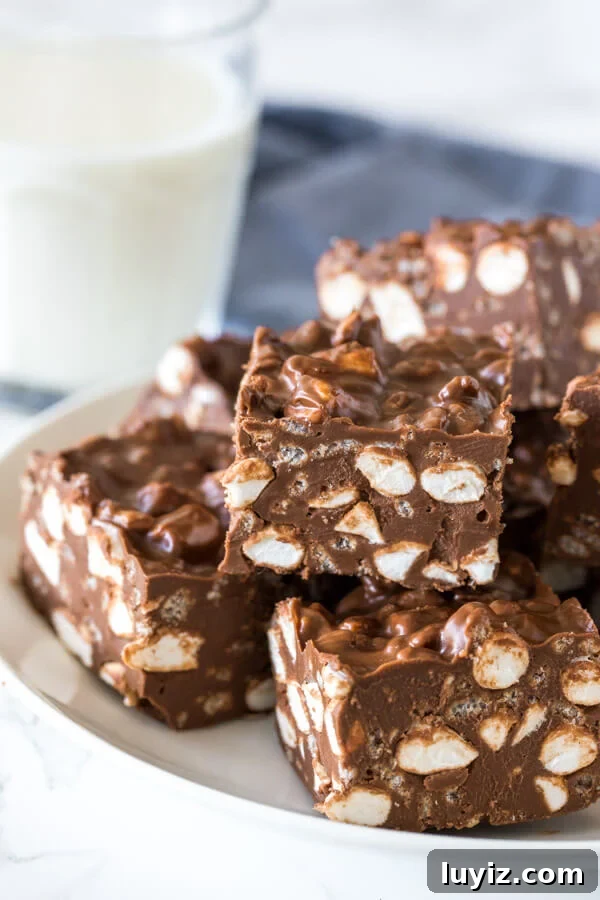 No-Bake Rocky Road Bars Recipe: Creamy Chocolate Marshmallow Squares 2 A plate of no bake rocky road bars with marshmallows and Rice Krispies