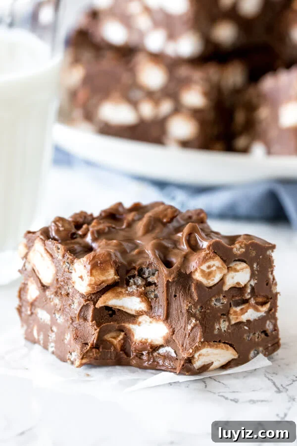 No-Bake Rocky Road Bars Recipe: Creamy Chocolate Marshmallow Squares 5 A chewy rocky road bar with a bite taken out to show the gooey texture.