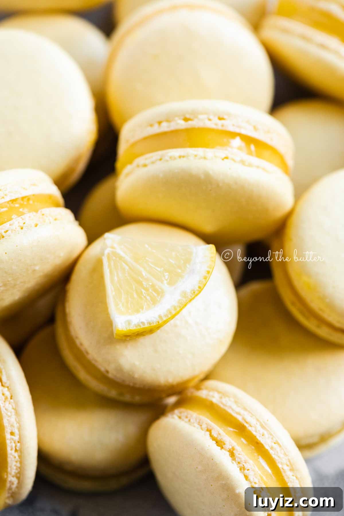 Zesty Lemon Bar Macarons: Tangy Citrus Sandwich Cookies 8 Close up of lemon bar macarons on side | All Images © Beyond the Butter™