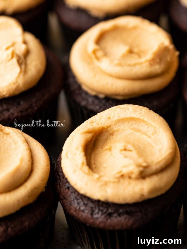 Moist Chocolate Zucchini Cake Recipe with Cocoa and Oil 9 Close up image of devil's food cupcakes topped with peanut butter frosting on a baking sheet.