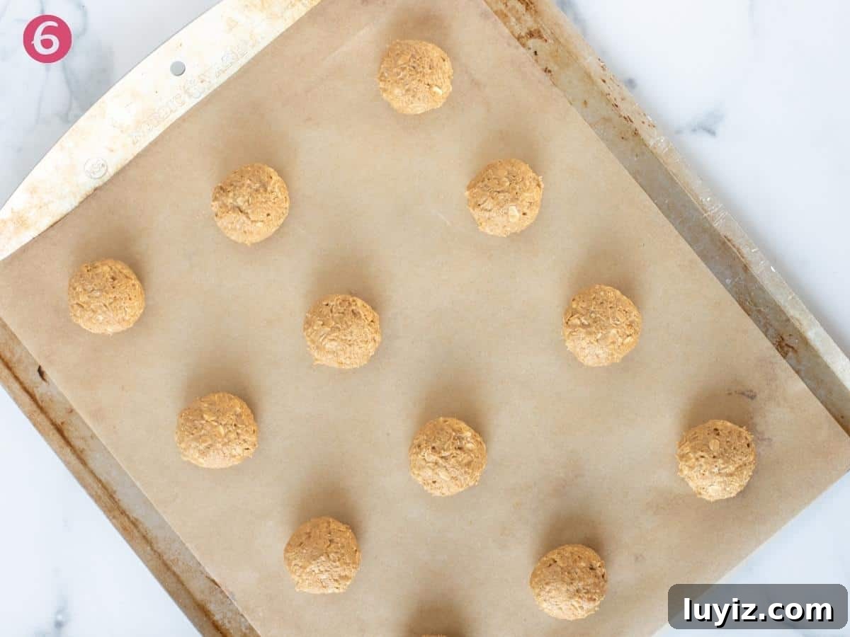 Chewy Peanut Butter Oatmeal Cookies Recipe for Perfect Bakes 5 Cookie dough balls on lined cookie sheet