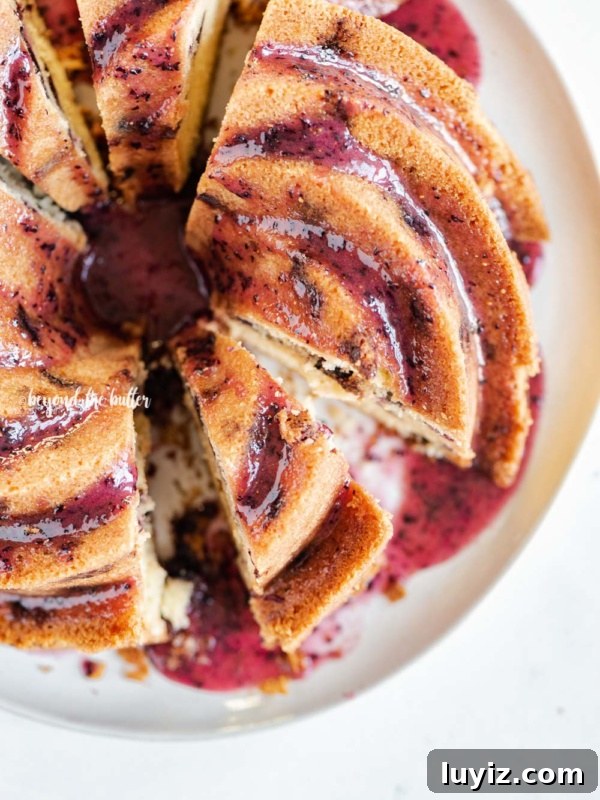Decadent Marble Bundt Cake Recipe with Swirled Chocolate-Vanilla 18 Overhead image of sliced blueberry bundt cake with blueberry glaze drizzled over the top.