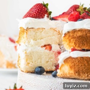 Light and Fluffy Homemade Angel Food Cake Recipe 9 Angel food cake with one slice pulled out on a ceramic cake stand