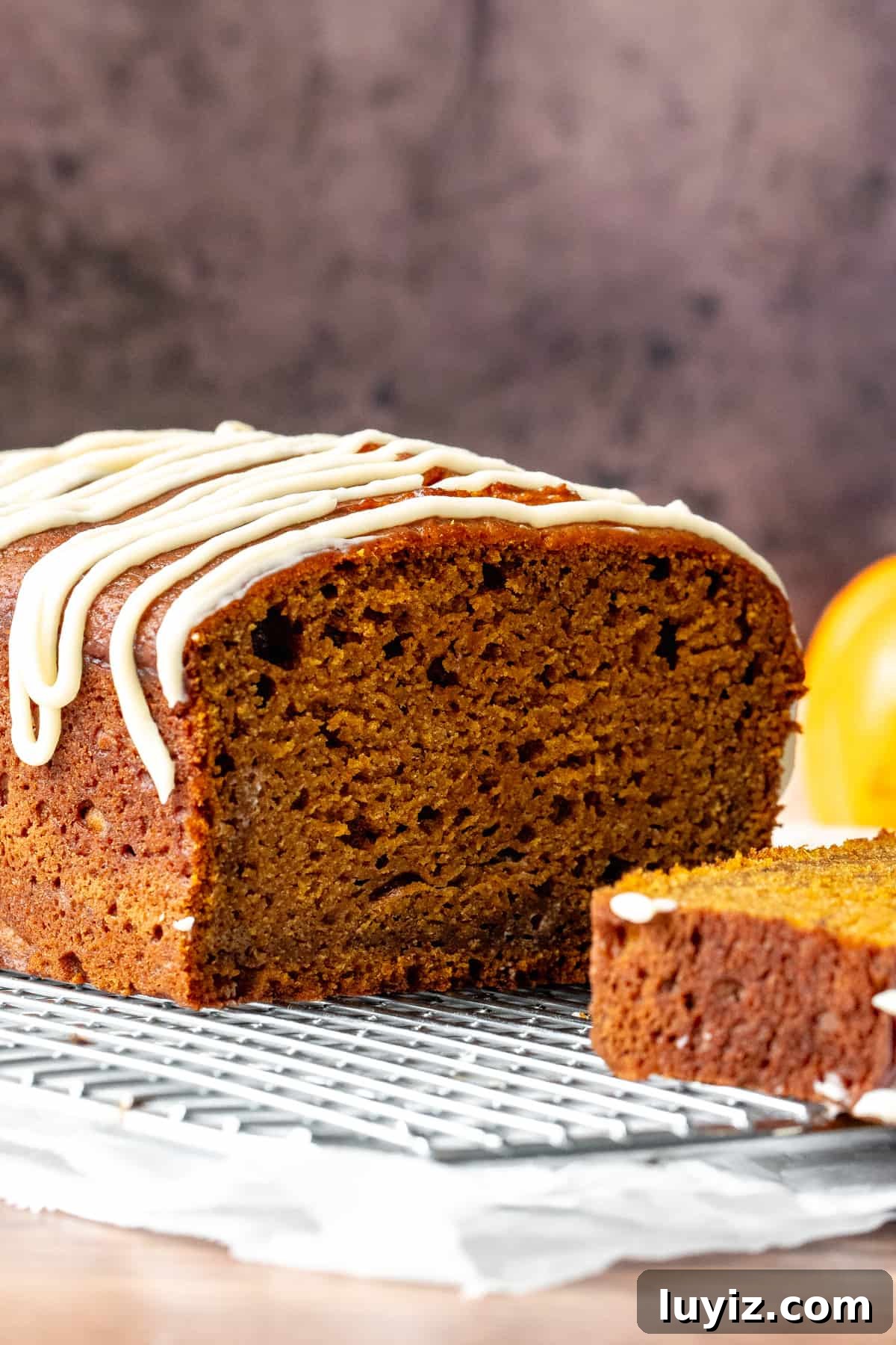 Moist Pumpkin Bread with Cream Cheese Glaze Recipe 5 Half of a pumpkin loaf on a cooling rack