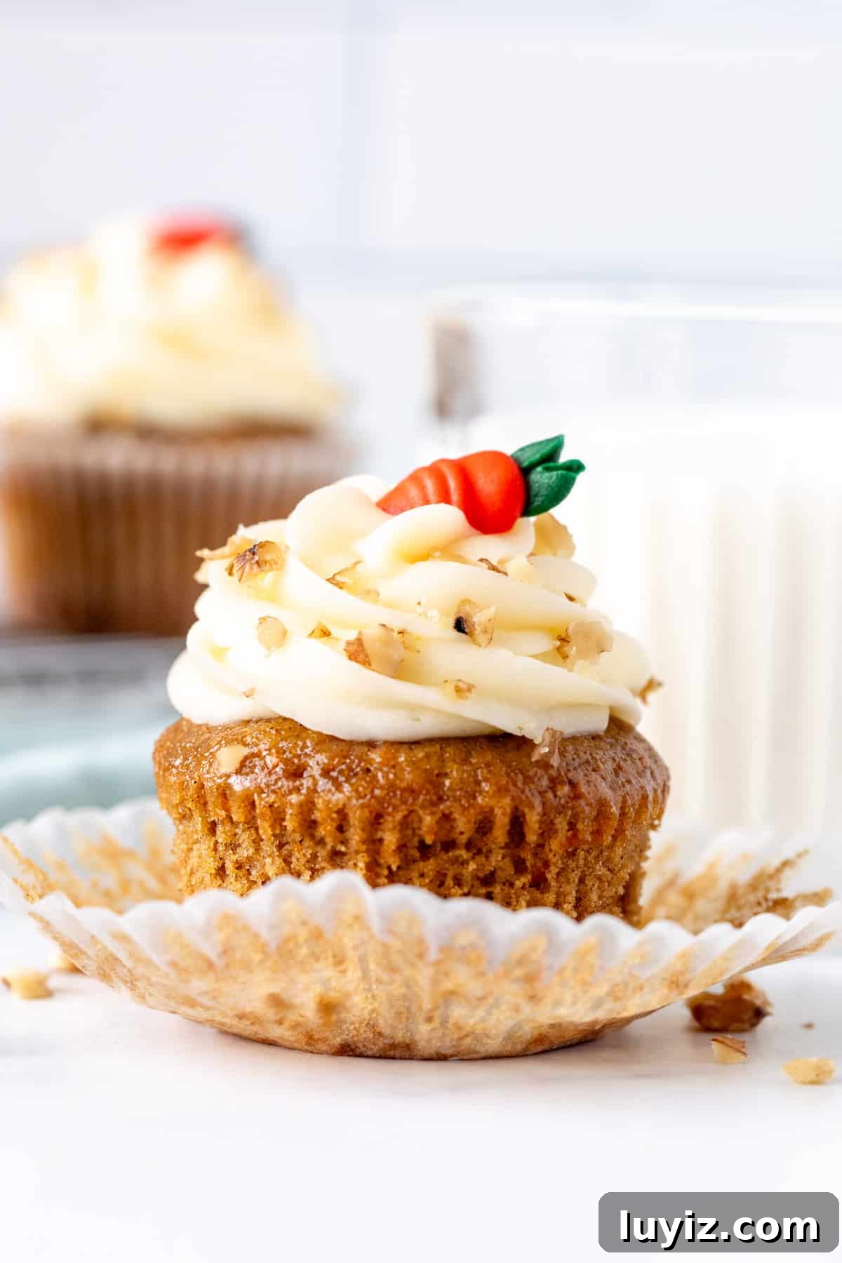 Moist Carrot Cupcakes with Cream Cheese Frosting 5 Carrot cake cupcake with muffin paper peeled back