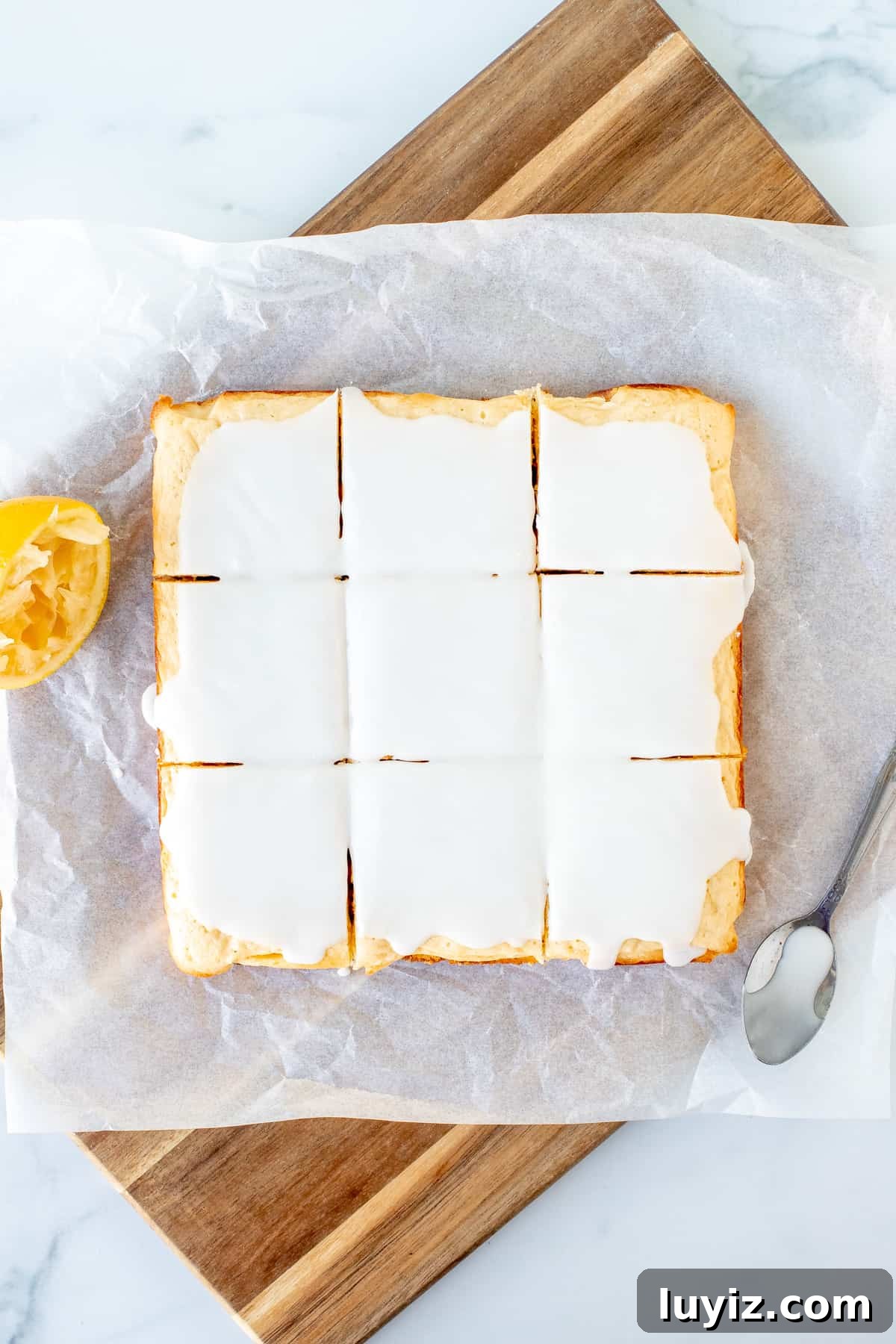 Lemon Blondies (Lemon Brownies) — Zesty Citrus Dessert Recipe 6 9 glazed lemon blondies on a cutting board.