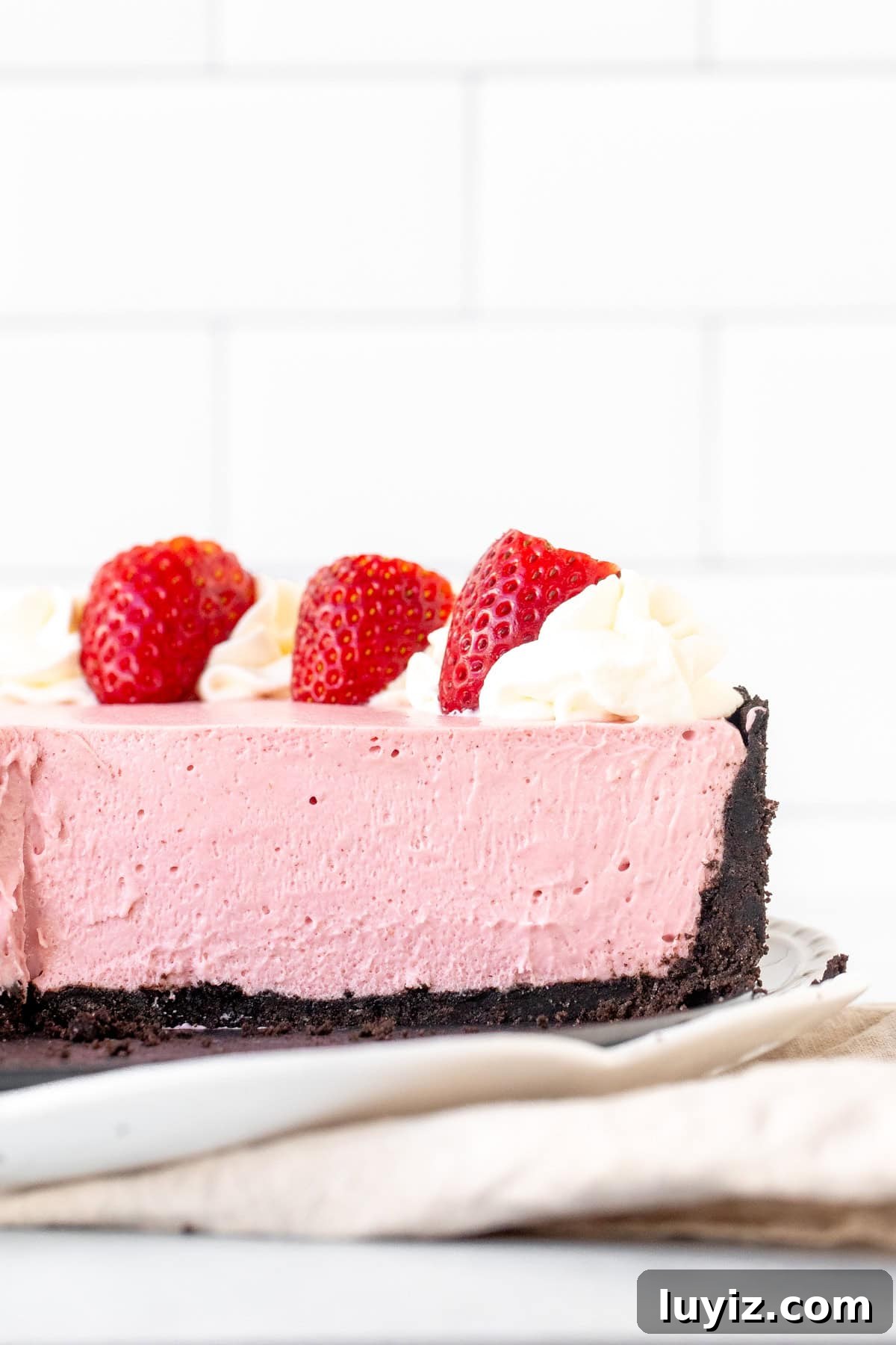 Creamy No-Bake Strawberry Cheesecake Recipe You’ll Love 7 Strawberry cheesecake with Oreo crust with slices cut from the cheesecake