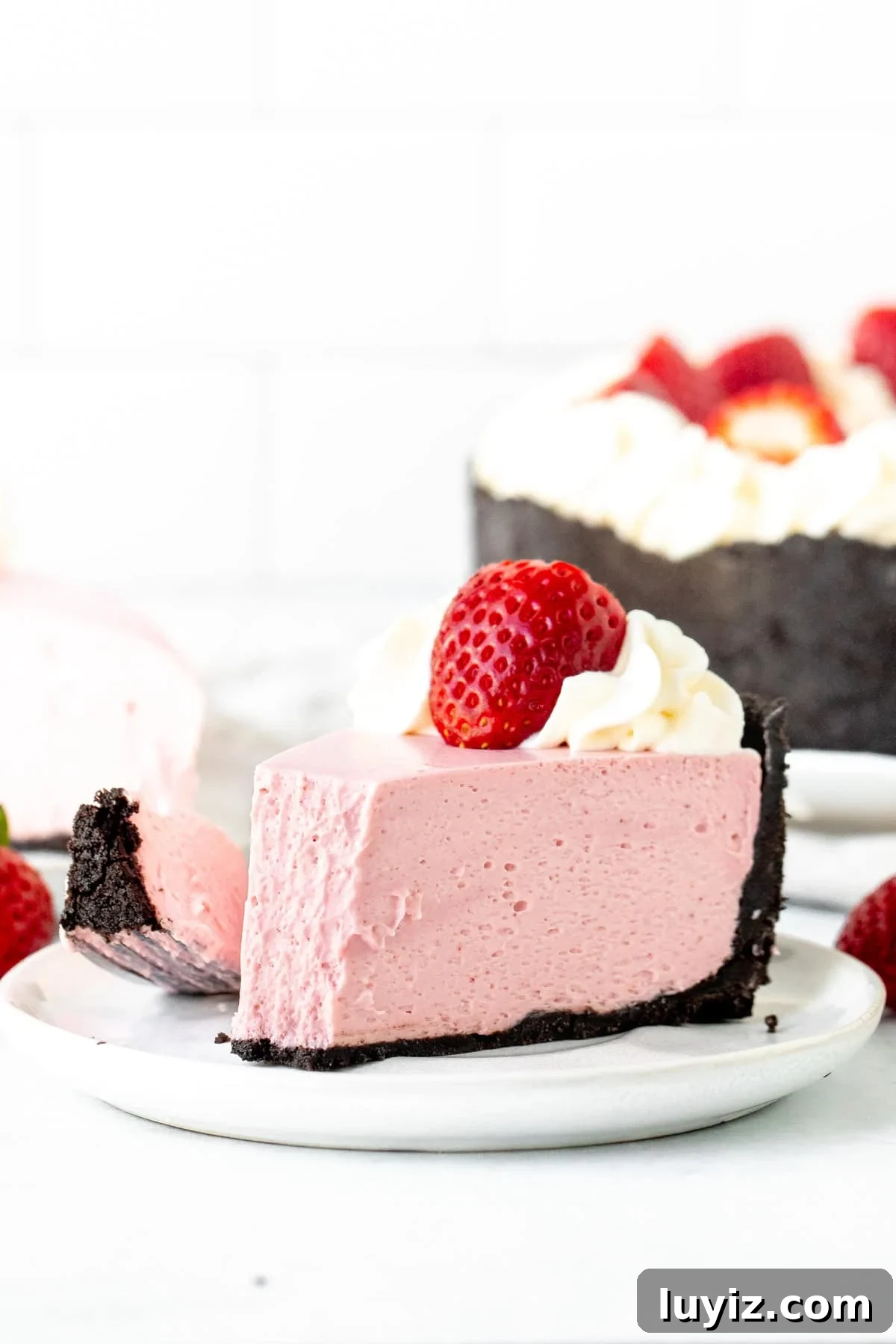 Creamy No-Bake Strawberry Cheesecake Recipe You’ll Love 8 Slice of no bake strawberry flavored cheesecake with bite taken out