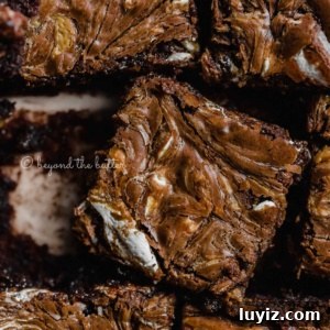 Marshmallow Peanut Butter Brownies Recipe — Gooey Chocolate Bars 9 Closeup of randomly placed marshmallow peanut butter brownies on parchment paper.