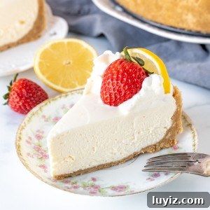 Piece of no-bake lemon cheesecake with graham crust and strawberry on top