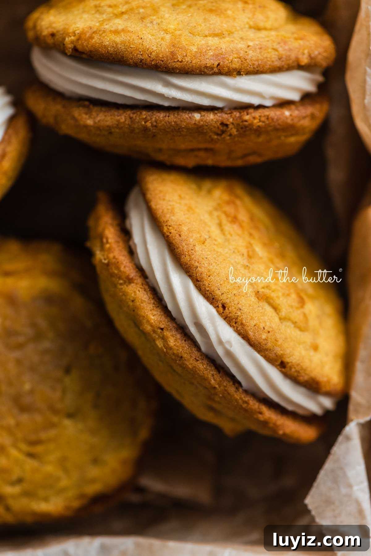 Pumpkin Whoopie Pies Recipe: Soft Spiced Sandwich Cookies 17 Pumpkin whoopie pies randomly positioned in a parchment paper lined baking tin.