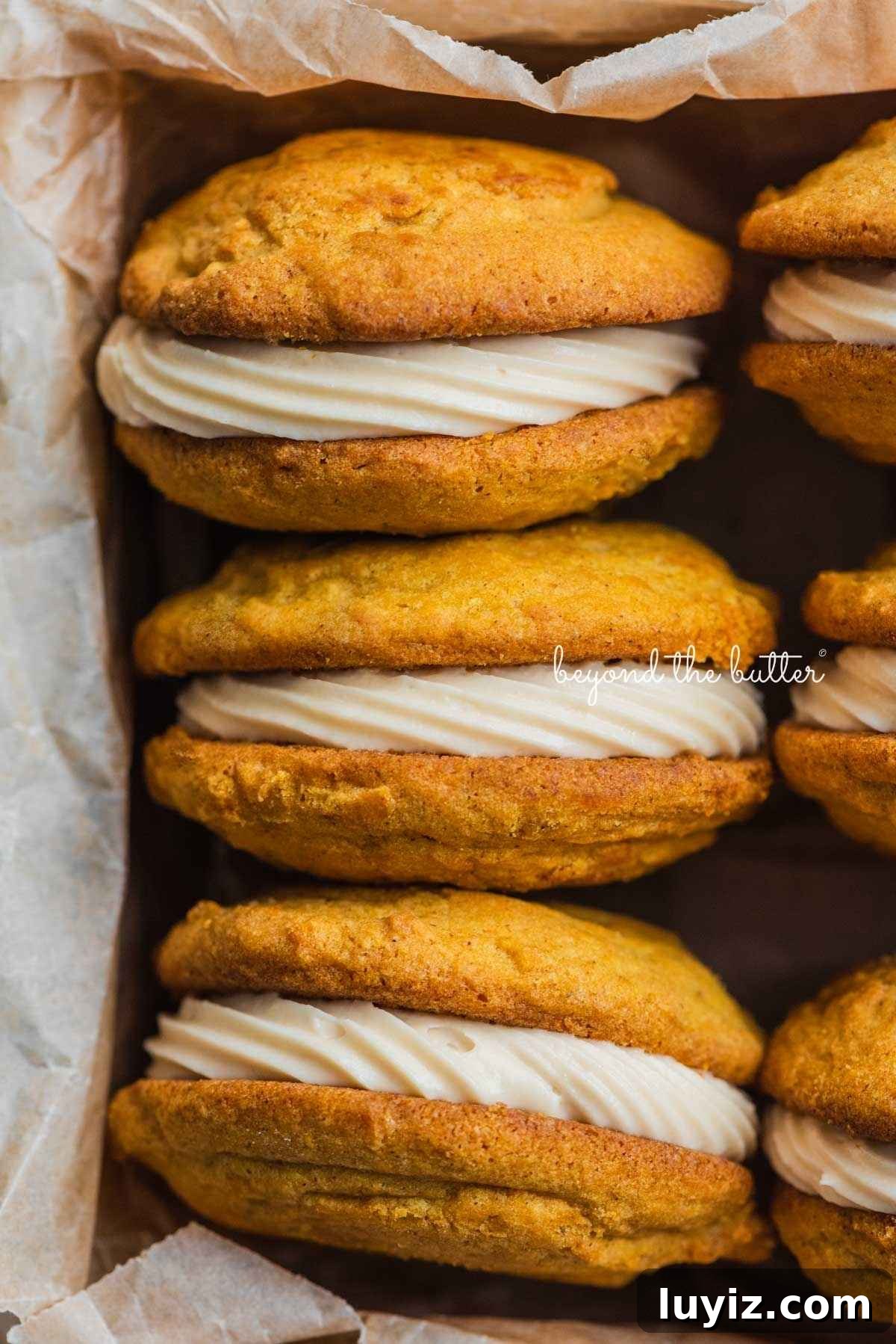 Pumpkin Whoopie Pies Recipe: Soft Spiced Sandwich Cookies 4 Six pumpkin whoopie pies filled with maple cream cheese frosting placed in a parchment paper lined metal baking tin.