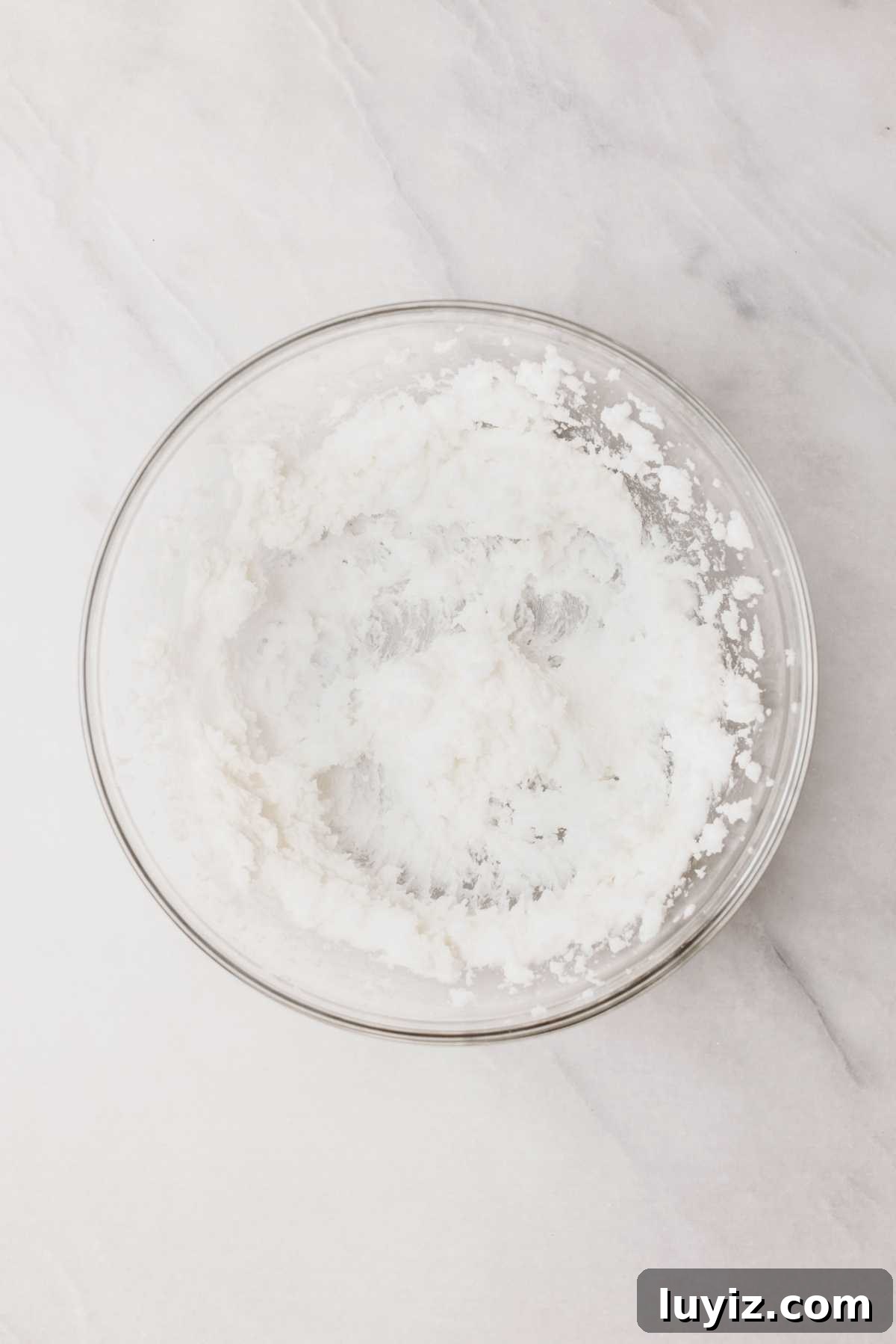 Pumpkin Whoopie Pies Recipe: Soft Spiced Sandwich Cookies 8 Vegetable shortening and granulated sugar beaten together in a large glass mixing bowl on a light grey marbled background.