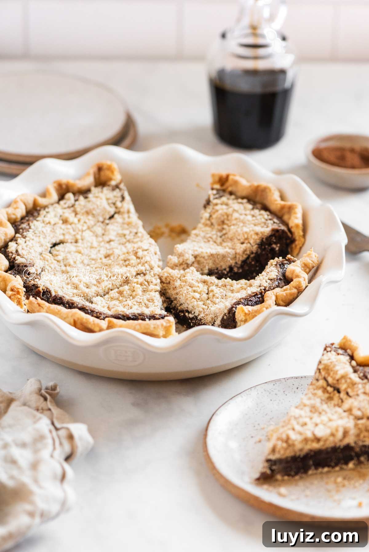 Classic Shoofly Pie Recipe: Molasses Crumb Pie from Pennsylvania 3 Pie plate with slices of pennsylvania dutch shoo fly pir removed and set on dessert plates with glass of molasses in the background | All Images © Beyond the Butter™