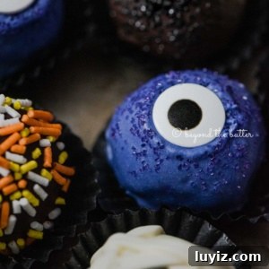 Decadent Homemade Chocolate Truffle Recipe You Can Make Tonight 9 Closeup of Halloween chocolate truffles in wrappers on dark gray background.