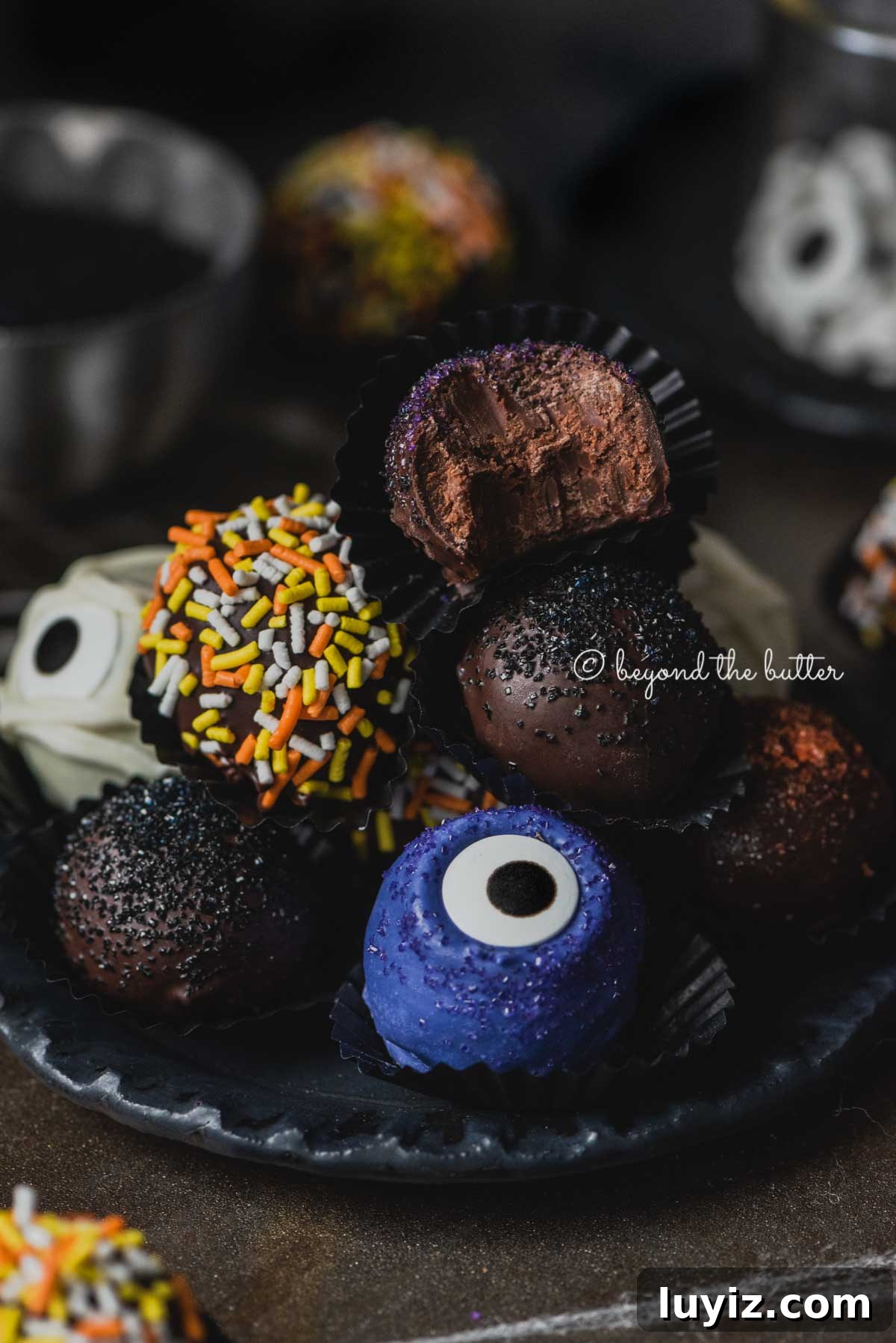 Decadent Homemade Chocolate Truffle Recipe You Can Make Tonight 4 Plate of stacked homemade chocolate truffles with more around it on dark background | All Images © Beyond the Butter®