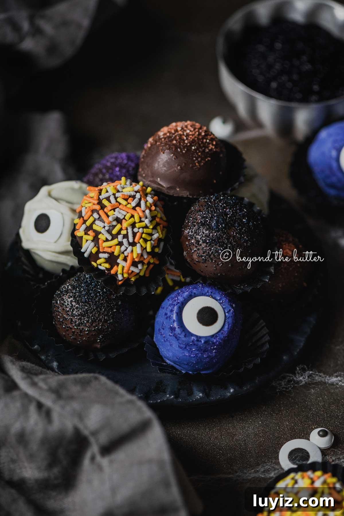 Decadent Homemade Chocolate Truffle Recipe You Can Make Tonight 8 Plate of stacked homemade chocolate truffles with more around it on dark background | All Images © Beyond the Butter®