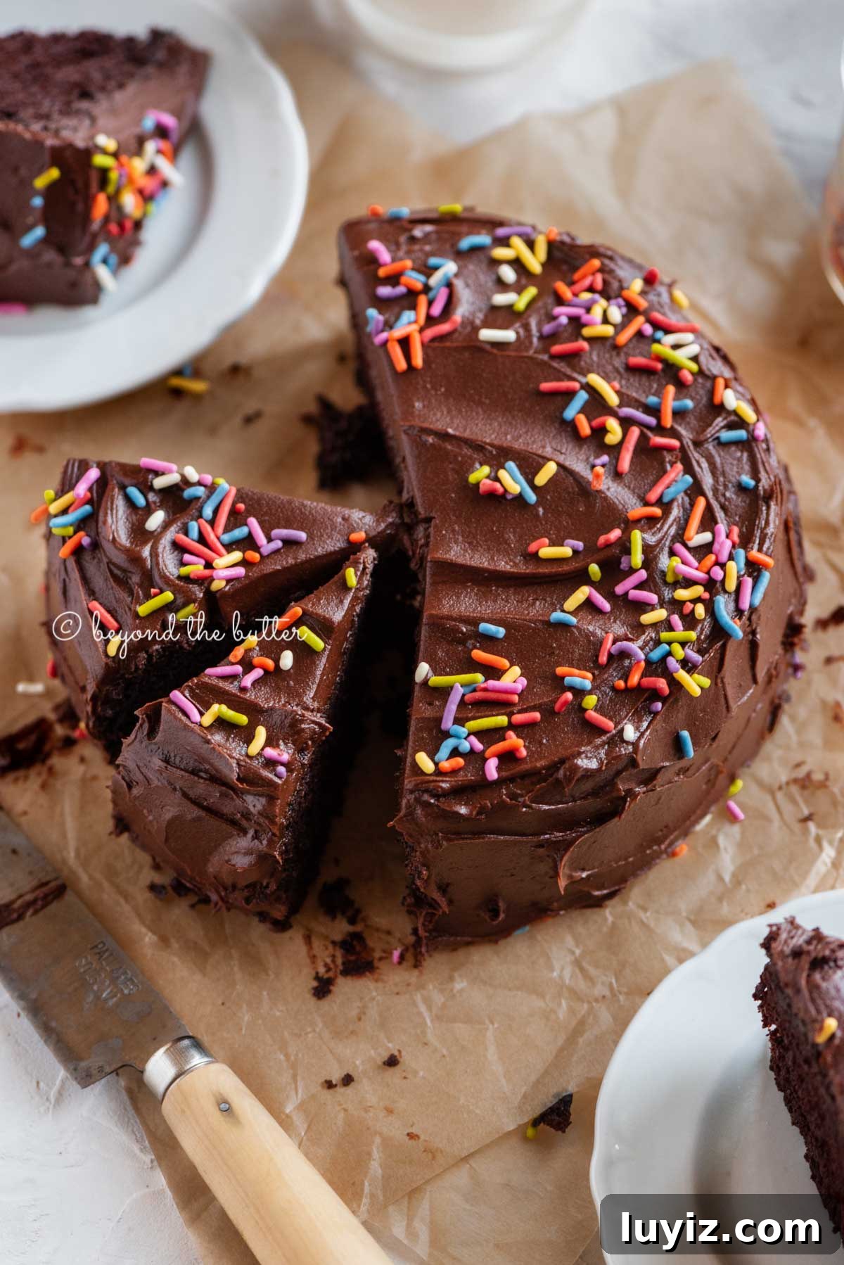Decadent Single-Layer Chocolate Cake Recipe for One Pan 2 Angled image of sliced single layer chocolate cake on parchment paper | All Images © Beyond the Butter™