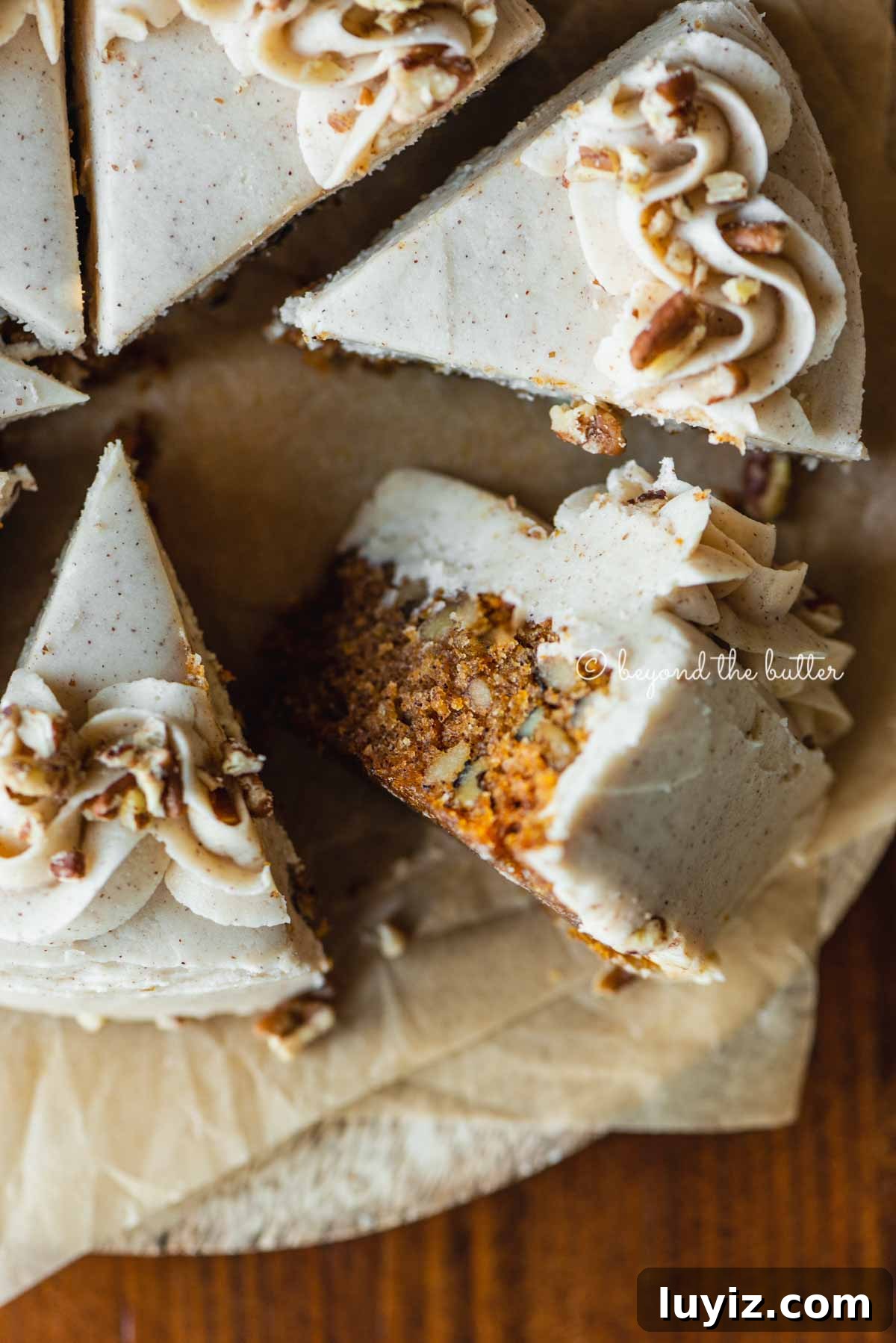 Moist One-Layer Carrot Cake Recipe for Any Occasion 3 Overhead closeup image of single layer carrot cake frosted on parchment paper and placed on a wood dining room table | All Images © Beyond the Butter®