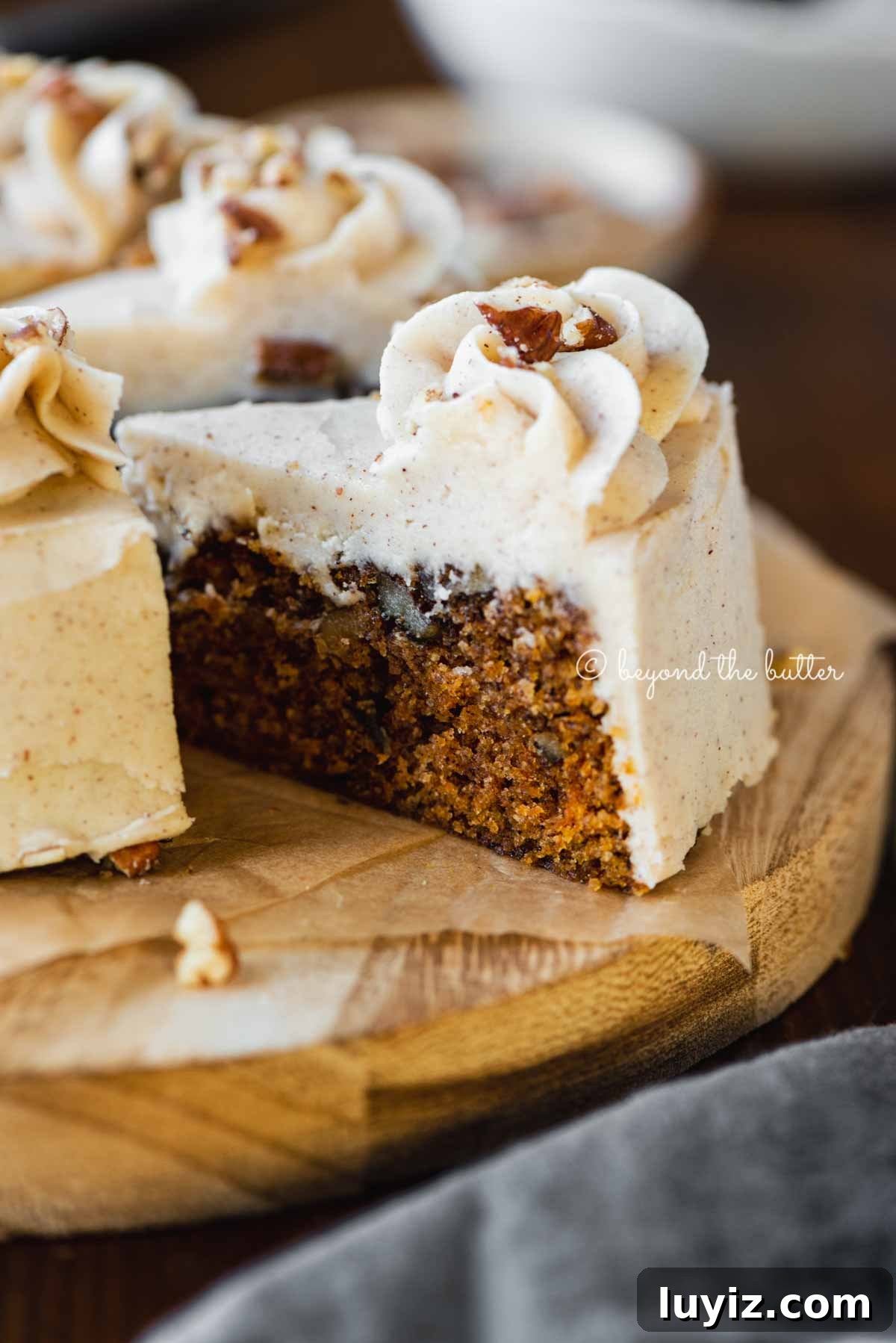 Moist One-Layer Carrot Cake Recipe for Any Occasion 6 Angled closeup image of sliced 6 inch single layer carrot cake on parchment paper | All Images © Beyond the Butter®