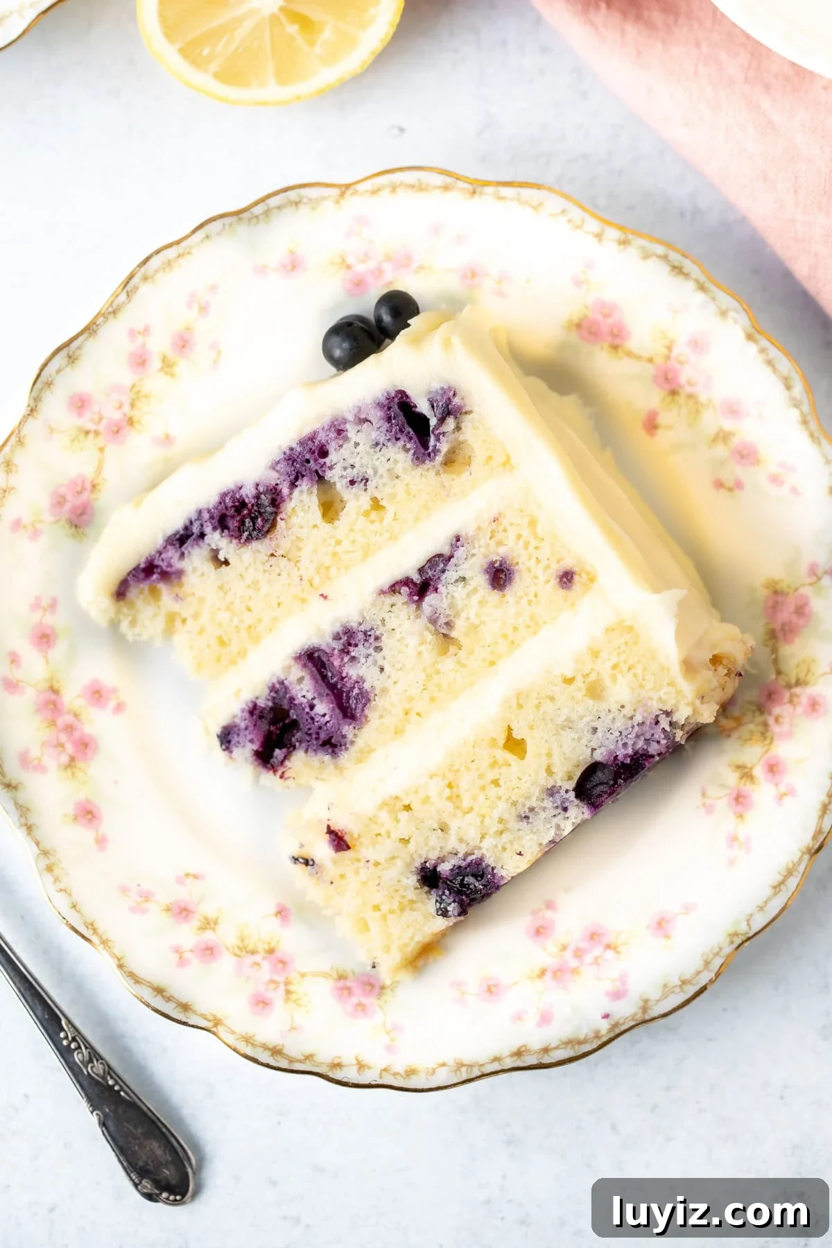 Lemon Blueberry Layer Cake Recipe with Zesty Glaze 10 Piece of lemon blueberry cake with three layers and crema cheese frosting